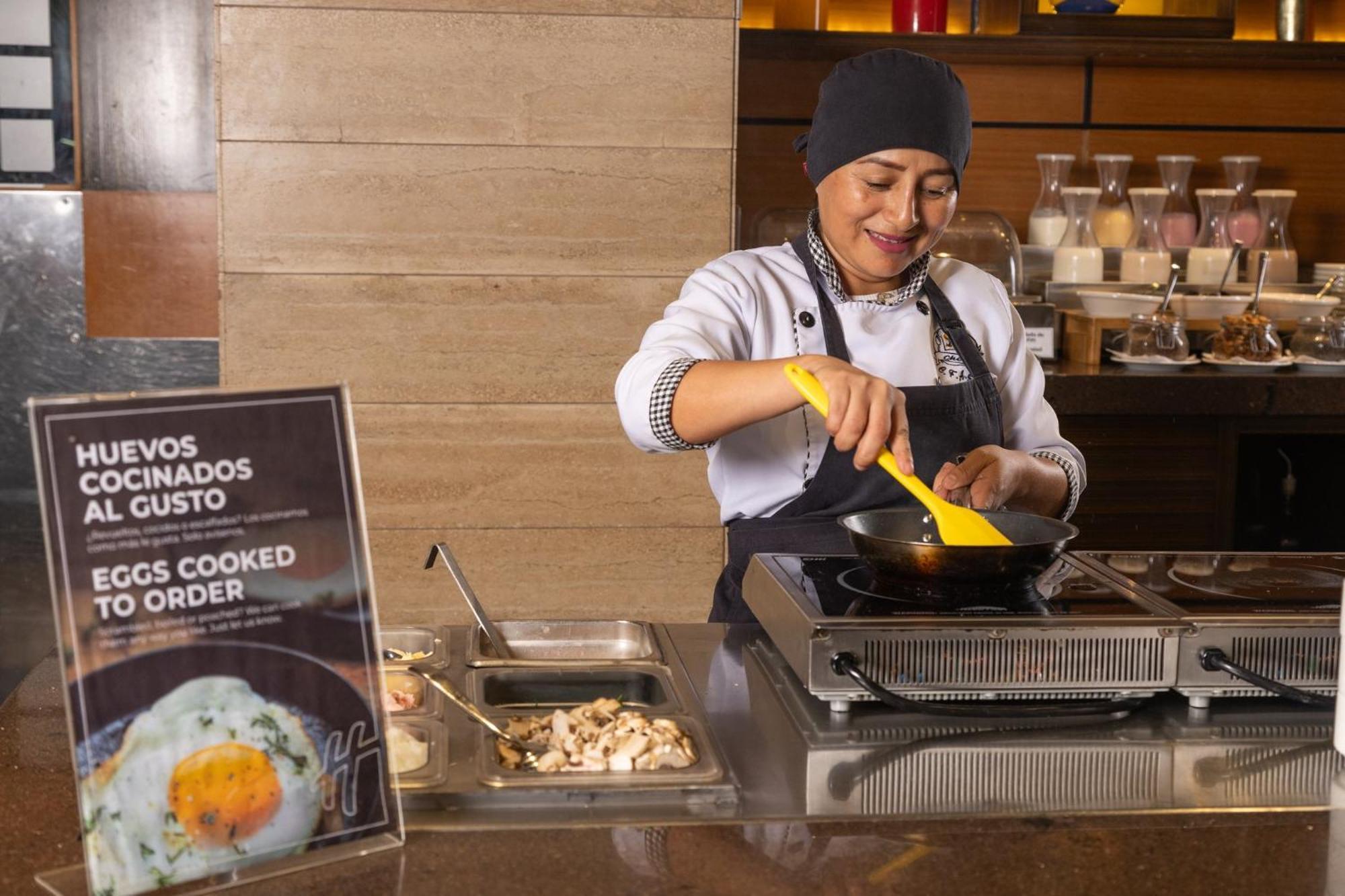 Holiday Inn Guayaquil Airport By Ihg Buitenkant foto A woman cooking eggs